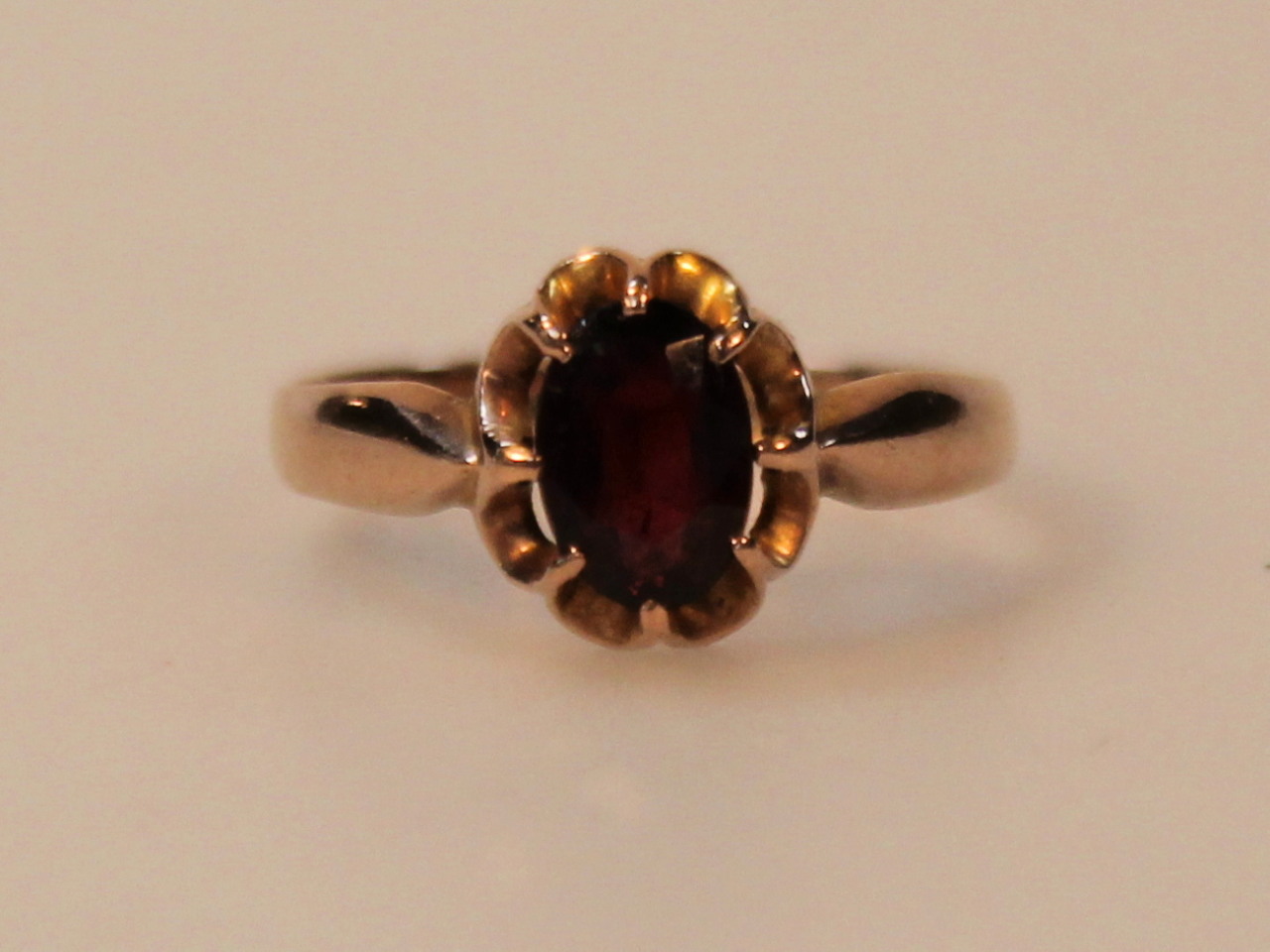 A ladies yellow metal and garnet ring, with claw set stone the shank marked 375, size O, 2.3g.