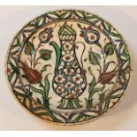 A 17thC Iznic pottery charger, polychrome decorated with a vessel flanked by flowers,