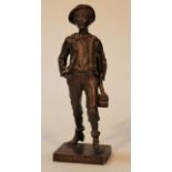 A 20thC spelter figure, of a boy holding books and easel wearing hat on a rectangular base,