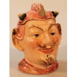 A late 19thC pottery tobacco jar, in the form of the devil, with removable hat, polychrome decorated