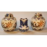 A pair of 20thC Delfia tin glazed earthenware jars and covers, each shouldered circular body