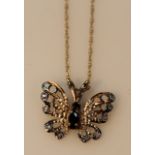A butterfly pendant, set with blue and white stones, 2cm high, attached to a yellow metal chain,