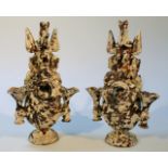 A pair of late 18thC Astbury style mottled pottery vases, each with horse head tops, above watch