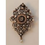 An Edwardian pendant brooch, the floral body set with pearls and centred with a white stone with a