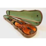 An early 20thC violin, with carved lion's head end, two piece back and articulated ebonised tuning