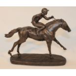 A 20thC resin spelter finish figure, of a jockey and racehorse, in full flight on naturalistic base,