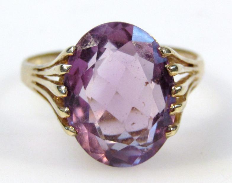 A ladies 9ct gold and amethyst ring, with an oval claw set stone, on a part pierced shank, size T,