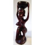 An African tribal hardwood figure, of a lady with her arms above her head holding bowl, scantly clad