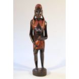 A 20thC African tribal figure group, of a lady stood semi-clad wearing loincloth, picked out in