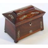 A 19thC rosewood and mother of pearl sarcophagus shaped tea caddy, the lid hinging to reveal a