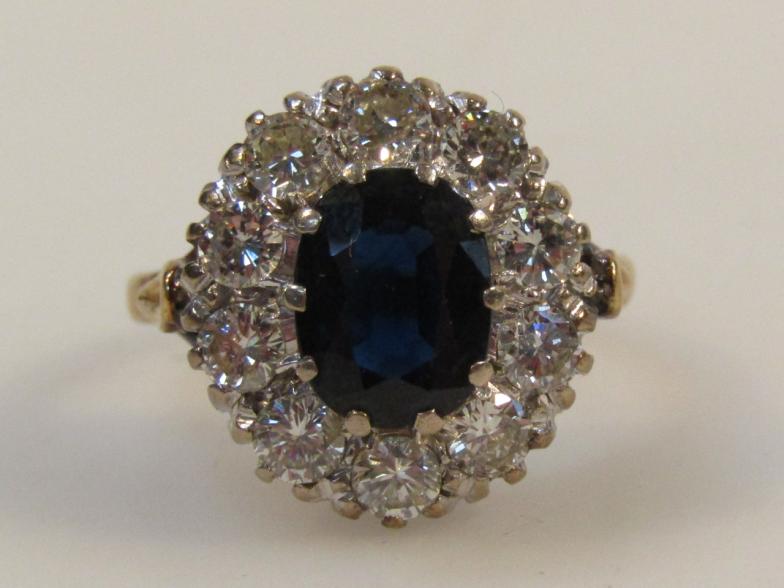 A ladies eleven stone sapphire and diamond cluster ring, with a central oval cut sapphire,