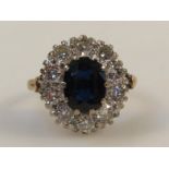 A ladies eleven stone sapphire and diamond cluster ring, with a central oval cut sapphire,