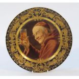 A 19thC Vienna porcelain plate, the circular body decorated with an abbot raising glass, with a