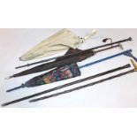 Various walking sticks and umbrellas, to include a silver topped cane, another with white metal