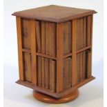 A 20thC miniature oak rotating bookcase, containing a quantity of Shakespeare plays in miniature