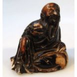 A Chinese soapstone figure, of a bearded sage in black and yellow in seated pose, carved in
