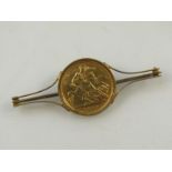 An Edwardian gold sovereign brooch, dated 1906, with a plain pin back and yellow metal setting,