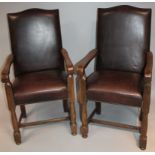 A pair of 20thC oak framed carver chairs, each with serpentine tops upholstered in (later) brown