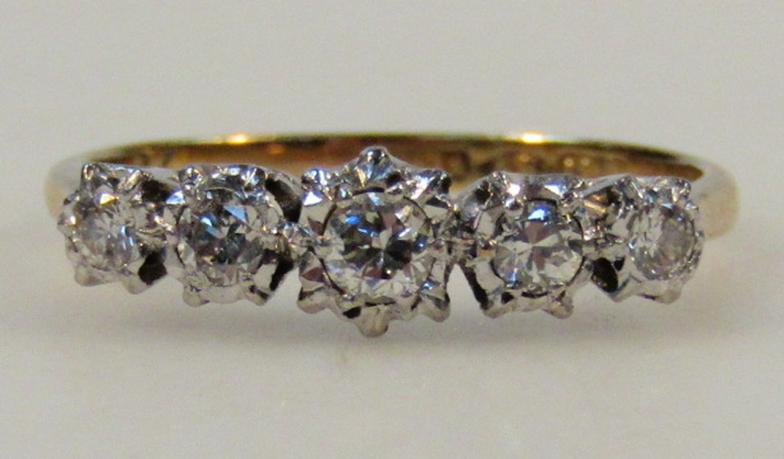A ladies five stone diamond ring, graduated illusion claw set, on a yellow metal shank marked 18ct