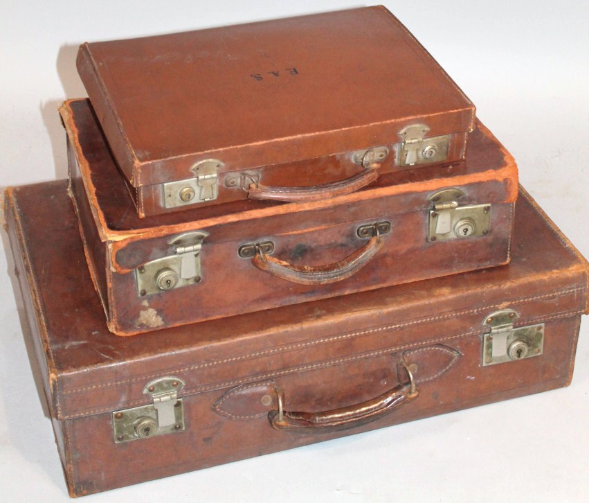 An early 20thC pressed brown leather travelling case, with exterior articulated metal locks and