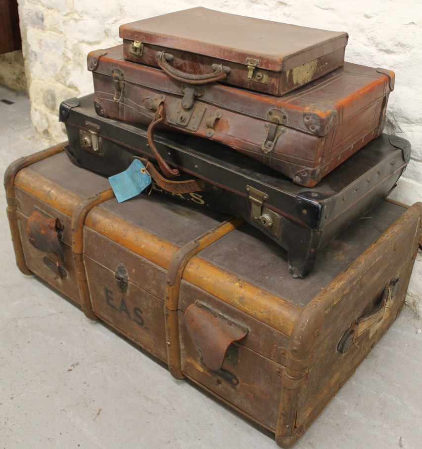 An early 20thC wooden bound and leather travelling trunk, with leather side handles and a part