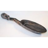 A 20thC carved African tribal spoon, ebonised with a geometric outline and figural head end, 61cm