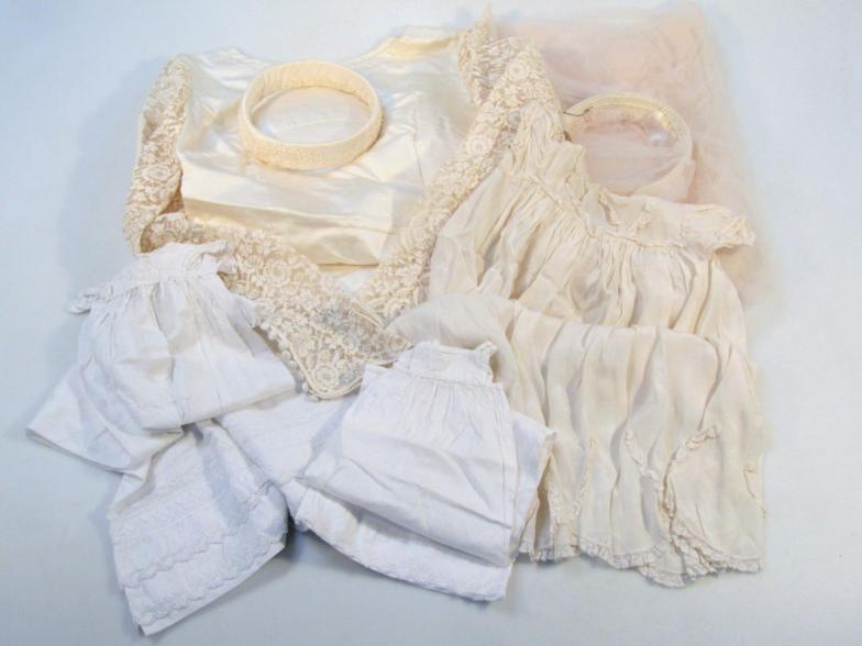 An early 20thC ivory silk wedding dress, to include veil and other overgarments in a Theresher &