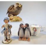 A Royal Copenhagen figure group, of two penguins each standing, decorated in grey, blue, peach,