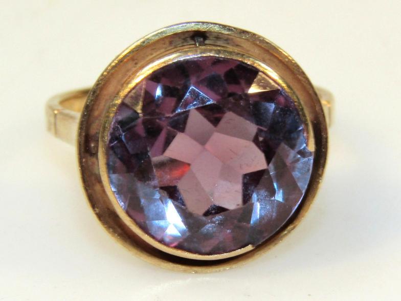 A ladies dress ring, with a blue stone on a yellow metal shank marked 18k, size Q.