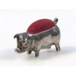 An early 20thC pin cushion, in the form a standing pig, with red material top, 3cm high, Continental