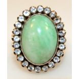 A ladies yellow metal dress ring, the oval central set polished green stone surrounded by small