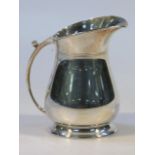 A George VI silver cream jug, by Harrison Brothers, the shaped spout and thumb mould 'C' handle a