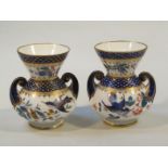 A pair of Derby style porcelain vases, each with bellied bodies and squat trumpet stems, decorated