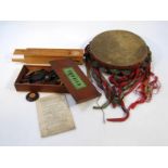 An early 20thC painted wooden tambourine, with metal central bells, 26cm wide, a set of squails in