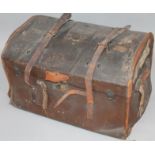 An early 20thC compressed leather bound travel trunk, the domed top hinging to reveal a fitted