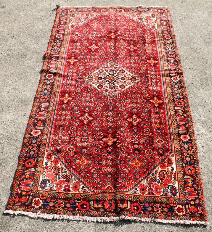 An Iranian Hamedan rug, in multicolour floral pattern, 302cm x 152cm.