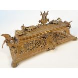 A late 19thC rococo brass inkstand, the rectangular hinged lid with a pierced top centred by a