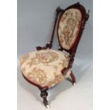 A Victorian walnut framed spoon back open chair, upholstered in (later) floral scroll material to