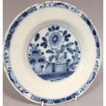 An 18thC English blue and white Delft plate, with a floral border, the main body decorated with