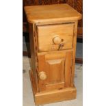 A modern rustic style stripped pine bedside cabinet, the overhanging D-end top raised above a single