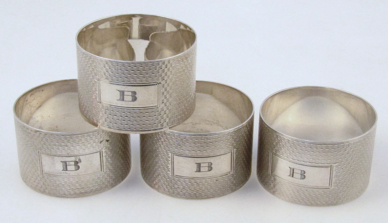 A set of four silver napkin rings, by H Bros, each circular body part engine turned and initialled