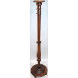 An Edwardian oak torchere stand, the circular dish top of small proportion raised on a baluster