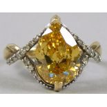 A diamond dress ring, with openwork twist frame, with central yellow diamond of approximately