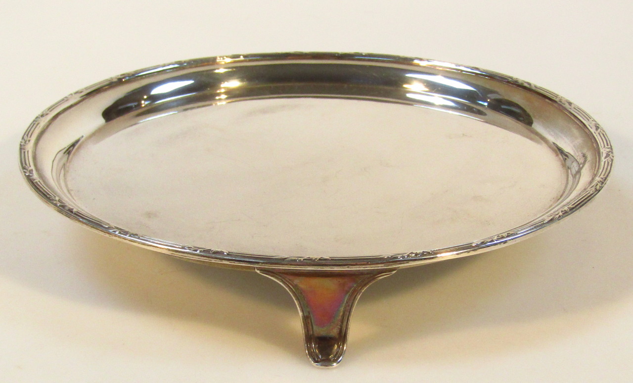 A George V silver waiter, by C J Vander, with a fluted rim broken by flower heads and plain circular