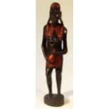 A 20thC African tribal figure group, of a lady stood semi-clad wearing loincloth, picked out in