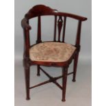 An Edwardian mahogany and boxwood strung corner chair, with a shaped top above a cylindrical and