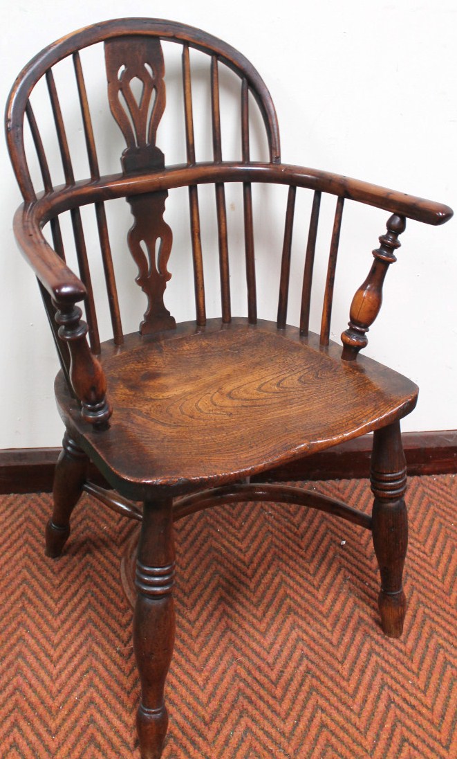 A 19thC Nottinghamshire yew wood and elm low back Windsor chair, with a hoop back centred by a