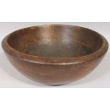 An English rustic treen dough bowl, with part carved decoration to the circular body on a circular
