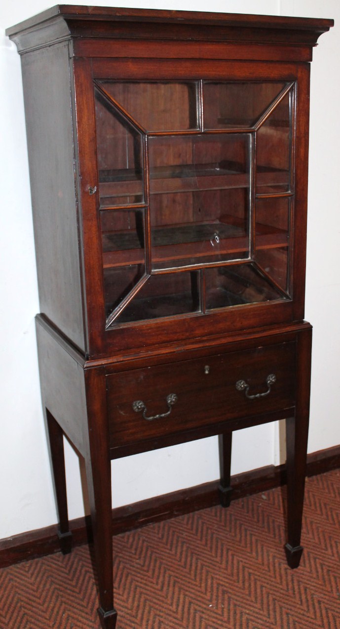 A 19thC mahogany display cabinet, with a carved overhanging top raised above an astragal glazed