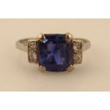 A ladies claw set sapphire ring, flanked by four small diamonds, the plain white metal shank